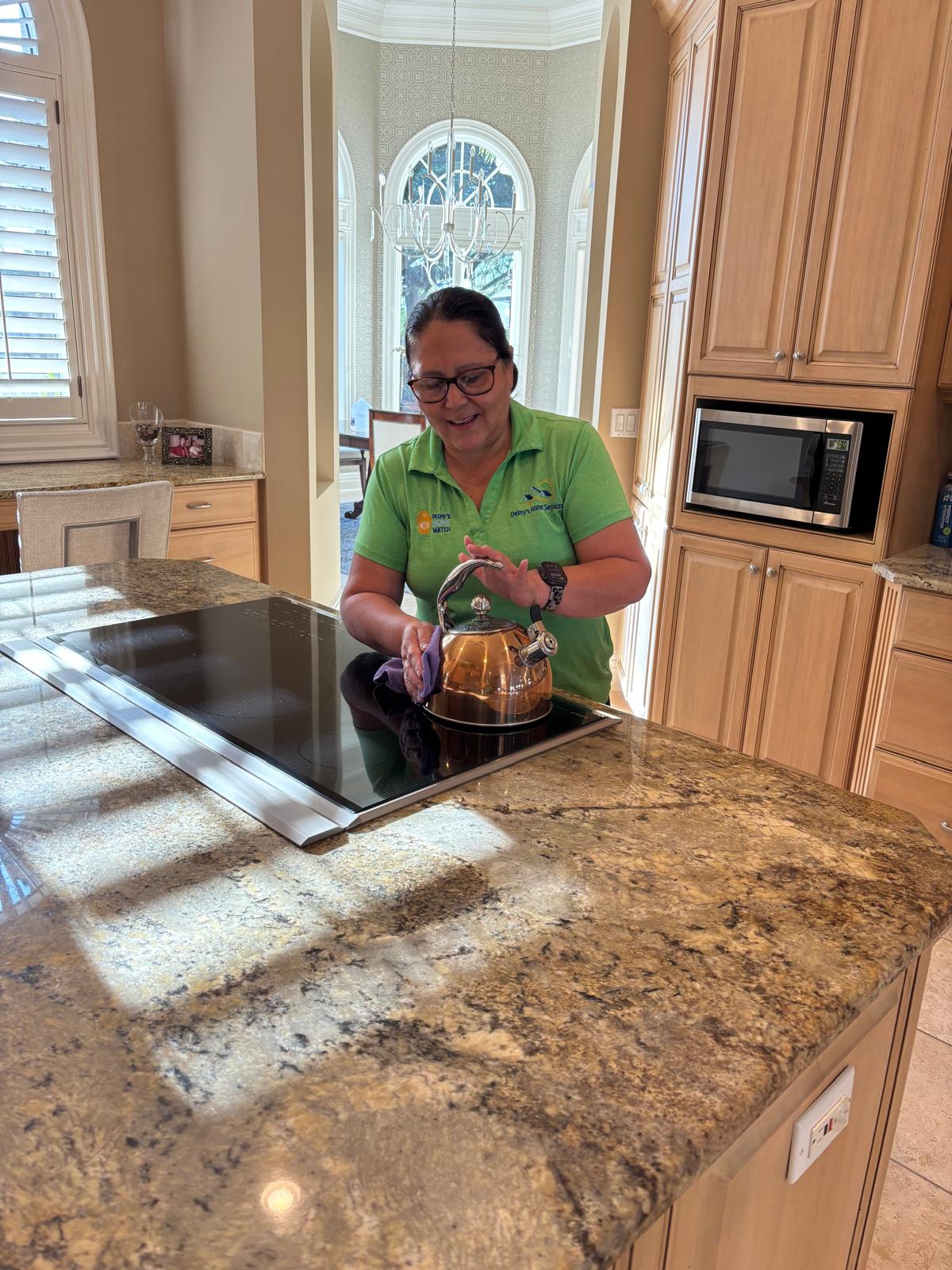Delmy's Home Services team member cleaning a luxury kitchen in Southwest Florida